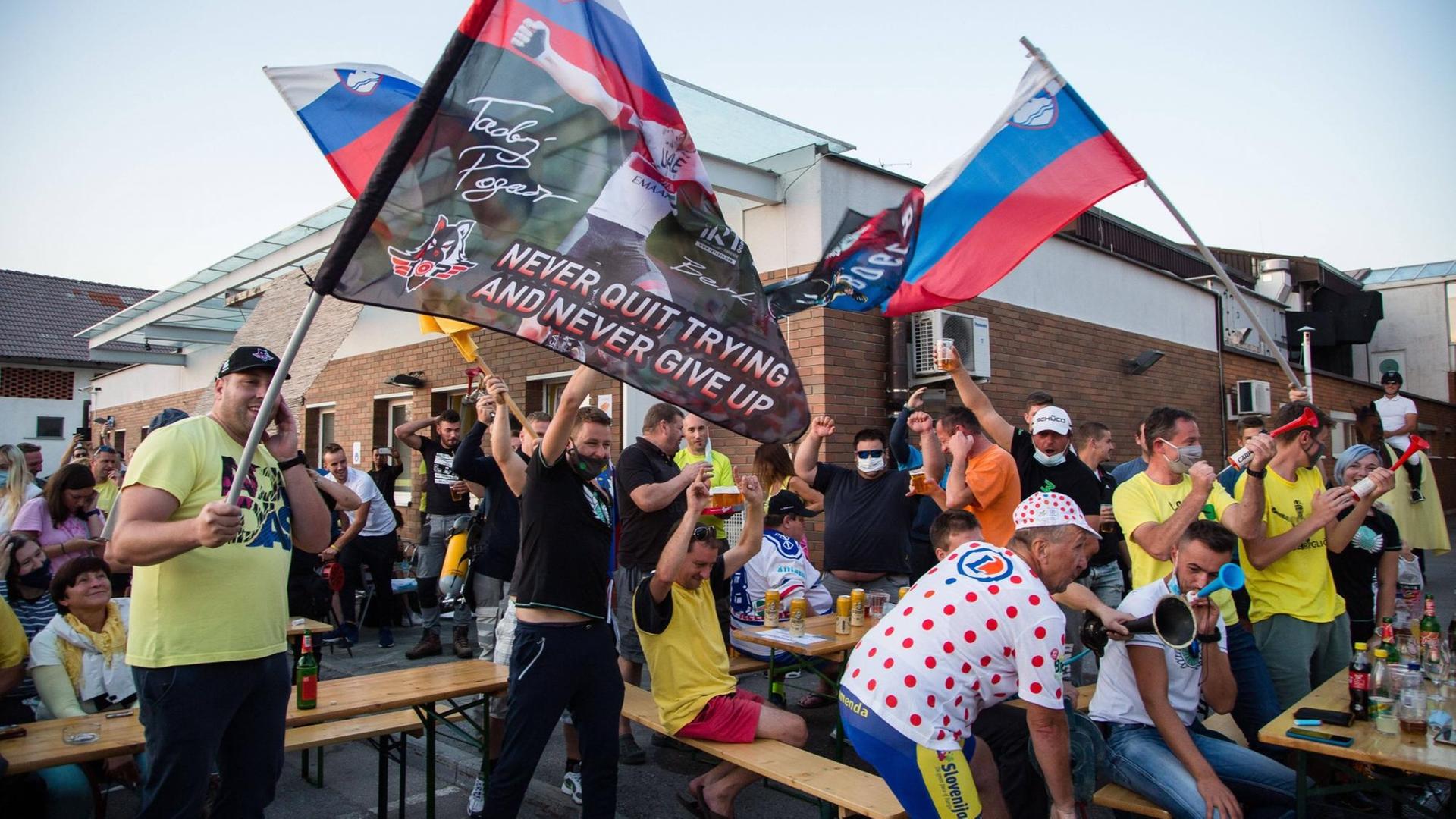 Slowenische Fans schwenken Flaggen zur Unterstützung der slowenischen Radfahrer Tadej Pogacar und Primoz Roglic während der Feier Slowenische Fans schwenken Flaggen zur Unterstützung der slowenischen Radfahrer Tadej Pogacar und Primoz Roglic während der Feier