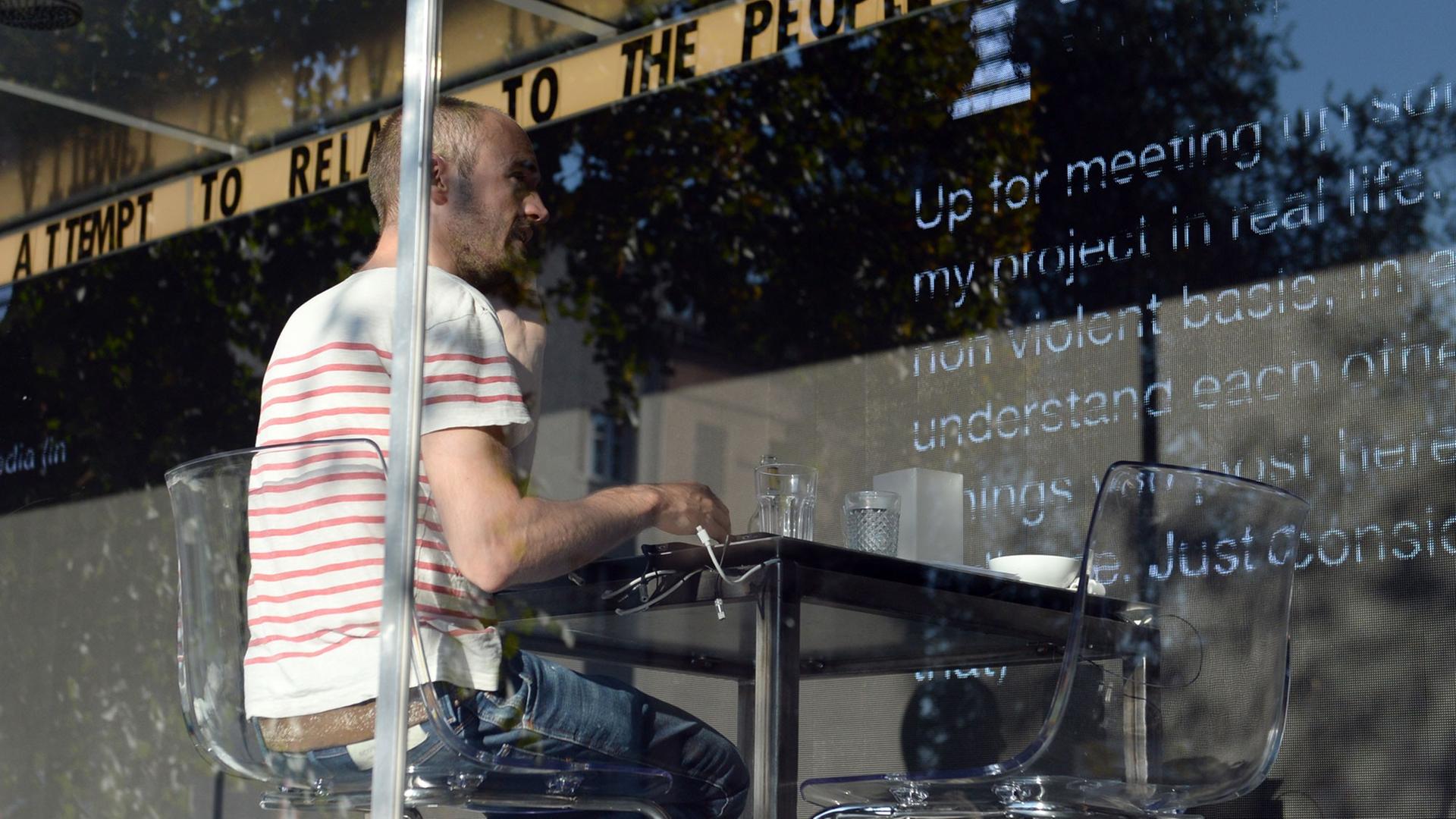 Der niederländische Künstler Dries Verhoeven sitzt am 04.010.2014 bei der Kunstaktion "wanna play ?" in einem Glascontainer auf dem Heinrichplatz in Berlin. Er chattet über die Dating-App Grindr während Passanten die Kommunikation auf einer LED-Wand hinter ihm mitverfolgen können. Der niederländische Künstler Dries Verhoeven sitzt am 04.010.2014 bei der Kunstaktion "wanna play ?" in einem Glascontainer auf dem Heinrichplatz in Berlin. Er chattet über die Dating-App Grindr während Passanten die Kommunikation auf einer LED-Wand hinter ihm mitverfolgen können.