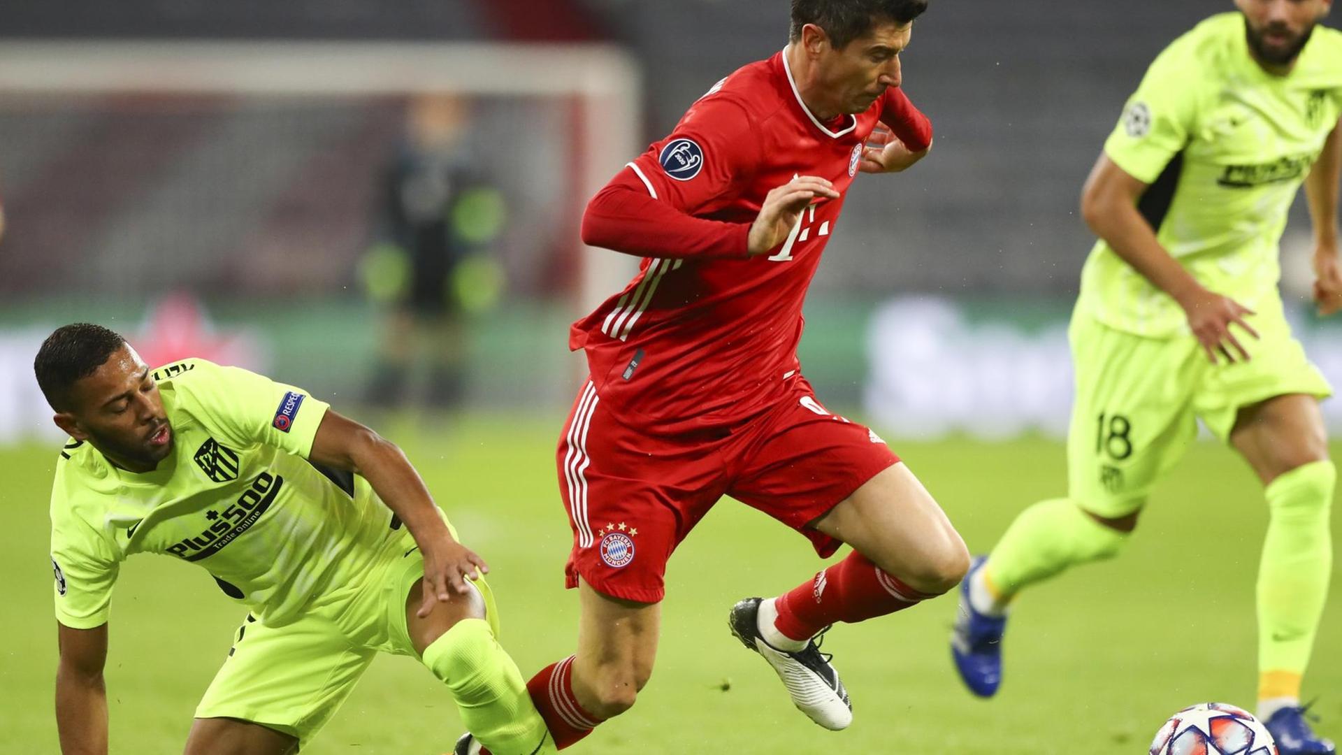 Bayern-Spieler Robert Lewandowski im roten Trikot im Zwei-Kampf mit Renan Lodi von Atletico Madrid. Bayern-Spieler Robert Lewandowski im roten Trikot im Zwei-Kampf mit Renan Lodi von Atletico Madrid.