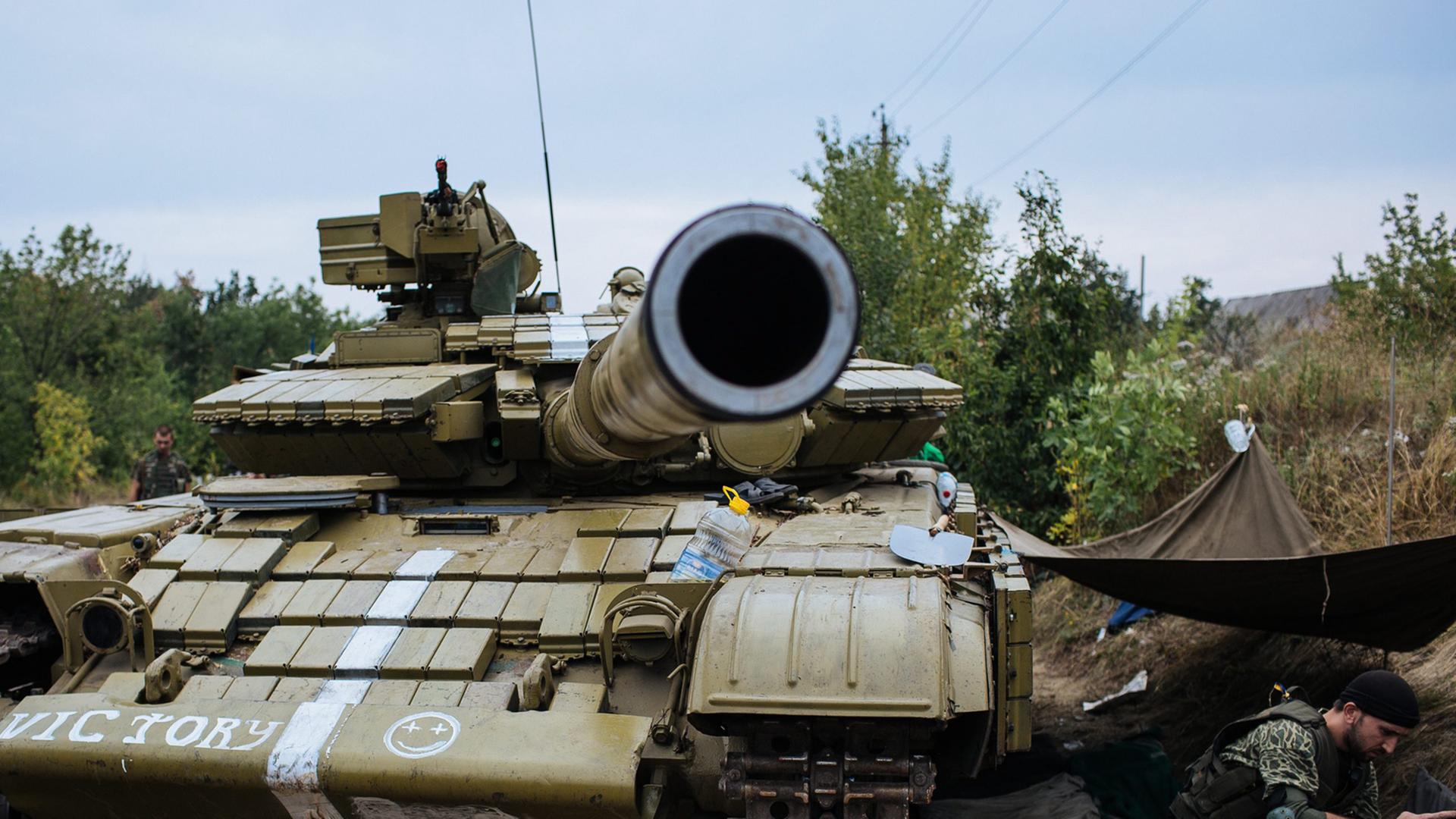 Ein ukrainischer Soldat sitzt neben einem Panzer im Osten der Ukraine. Ein ukrainischer Soldat sitzt neben einem Panzer im Osten der Ukraine.