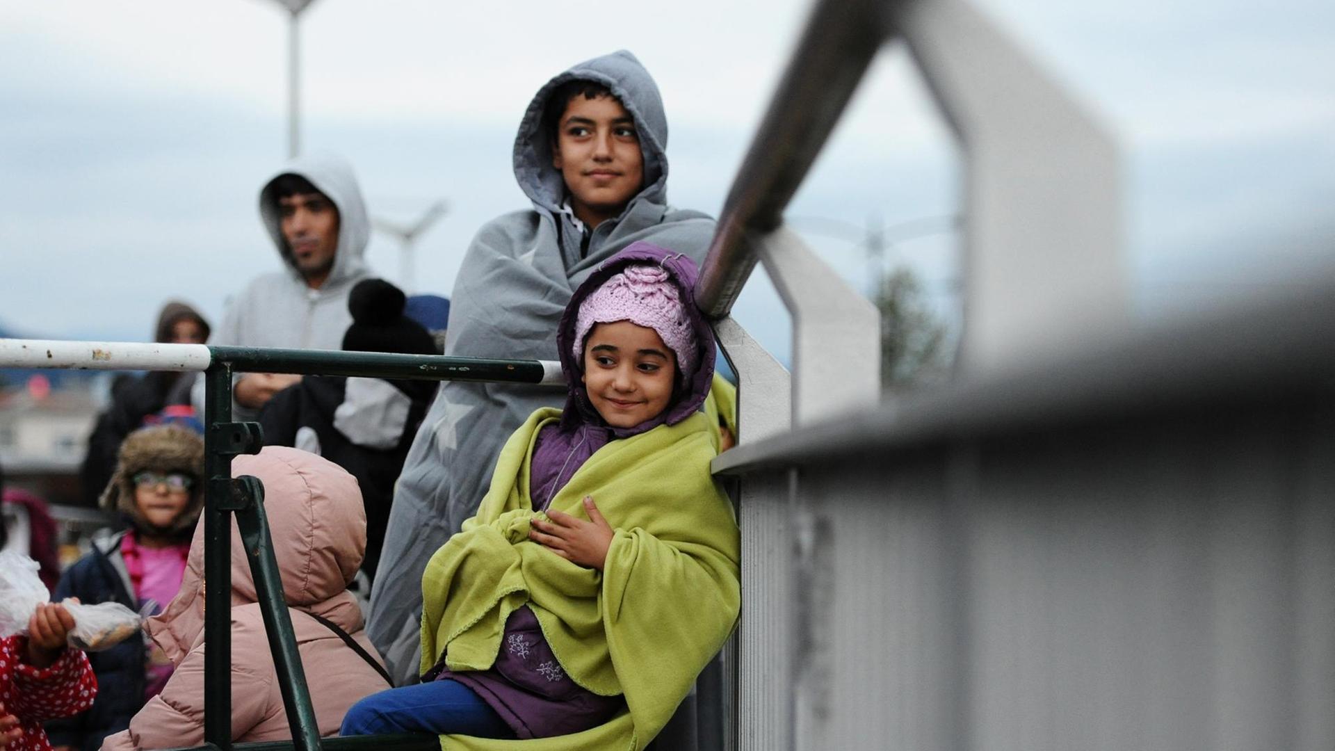 Kinder aus Afghanistan stehen am 20.09.2015 auf einer Brücke an der deutsch-österreichischen Grenze bei Salzburg und warten darauf, registriert und zu einer Flüchtlingsunterkunft in Freilassing gebracht zu werden, nachdem sie zu Fuß die Grenze überquert haben. Kinder aus Afghanistan stehen am 20.09.2015 auf einer Brücke an der deutsch-österreichischen Grenze bei Salzburg und warten darauf, registriert und zu einer Flüchtlingsunterkunft in Freilassing gebracht zu werden, nachdem sie zu Fuß die Grenze überquert haben.