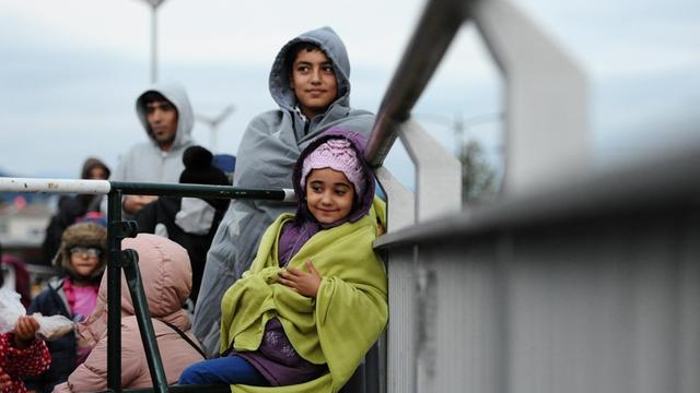Kinder aus Afghanistan stehen am 20.09.2015 auf einer Brücke an der deutsch-österreichischen Grenze bei Salzburg und warten darauf, registriert und zu einer Flüchtlingsunterkunft in Freilassing gebracht zu werden, nachdem sie zu Fuß die Grenze überquert haben.