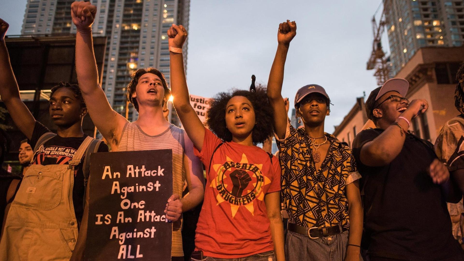 Junge Aktivisten bei der Demonstration gegen Polizeigewalt in Chicago, mit in die Höhe gehobenen Fäusten. Junge Aktivisten bei der Demonstration gegen Polizeigewalt in Chicago, mit in die Höhe gehobenen Fäusten.