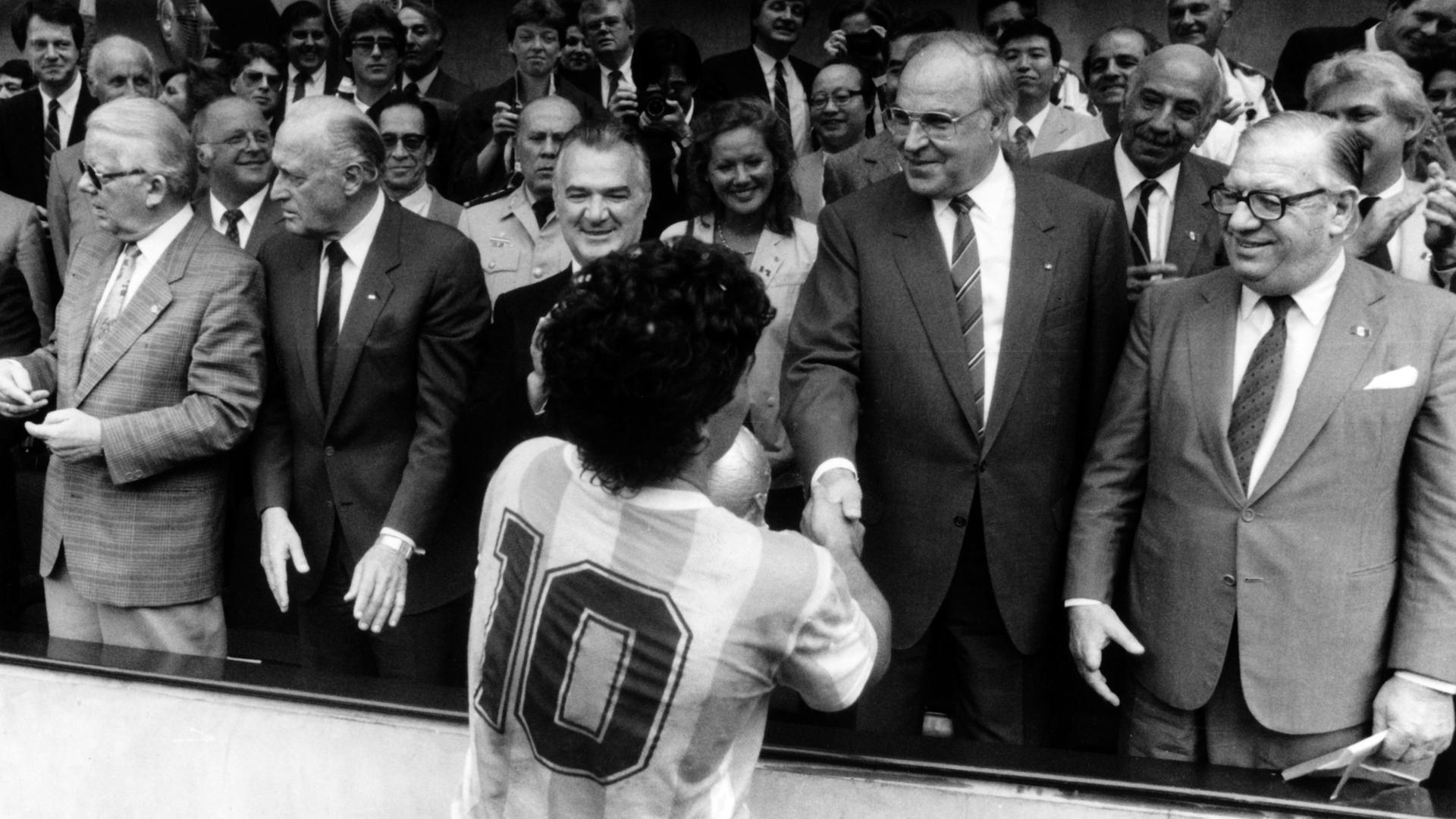 Bundeskanzler Helmut Kohl gratuliert dem Spielführer der argentinischen Fußballnationalmannschaft, Diego Maradona, nach dem Sieg im Finale um die WM in Mexiko Stadt am 29. Juni 1986.