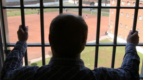 Ein Mann schaut aus einer Zelle der Strafanstalt Hamburg-Fuhlsbüttel.