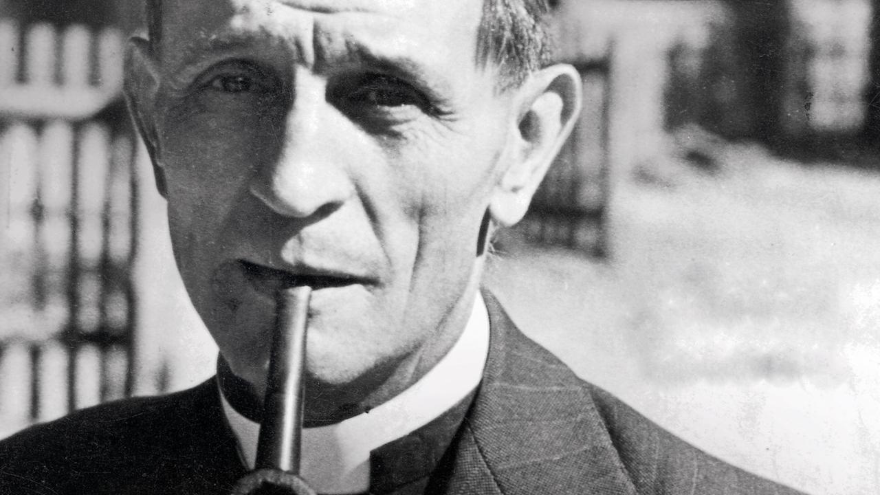 Eine historische Aufnahme von Martin Niemöller, evangelischer Pastor und Theologer, im Anzug und Pfeife im Mund. Eine historische Aufnahme von Martin Niemöller, evangelischer Pastor und Theologer, im Anzug und Pfeife im Mund.