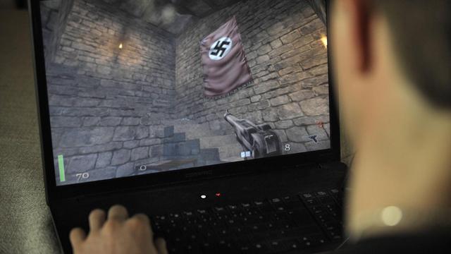 Ein Jugendlicher spielt an seinem Laptop das Killerspiel Wolfenstein.