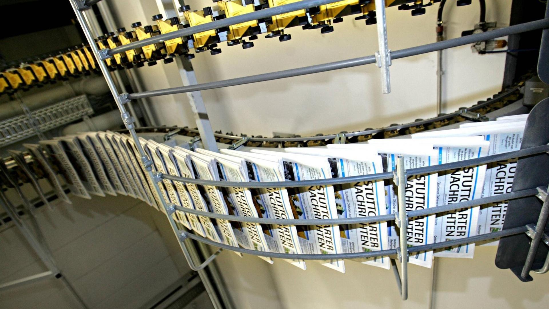 Exemplare der "Stuttgarter Nachrichten" im Förderband in der Druckerei Exemplare der "Stuttgarter Nachrichten" im Förderband in der Druckerei