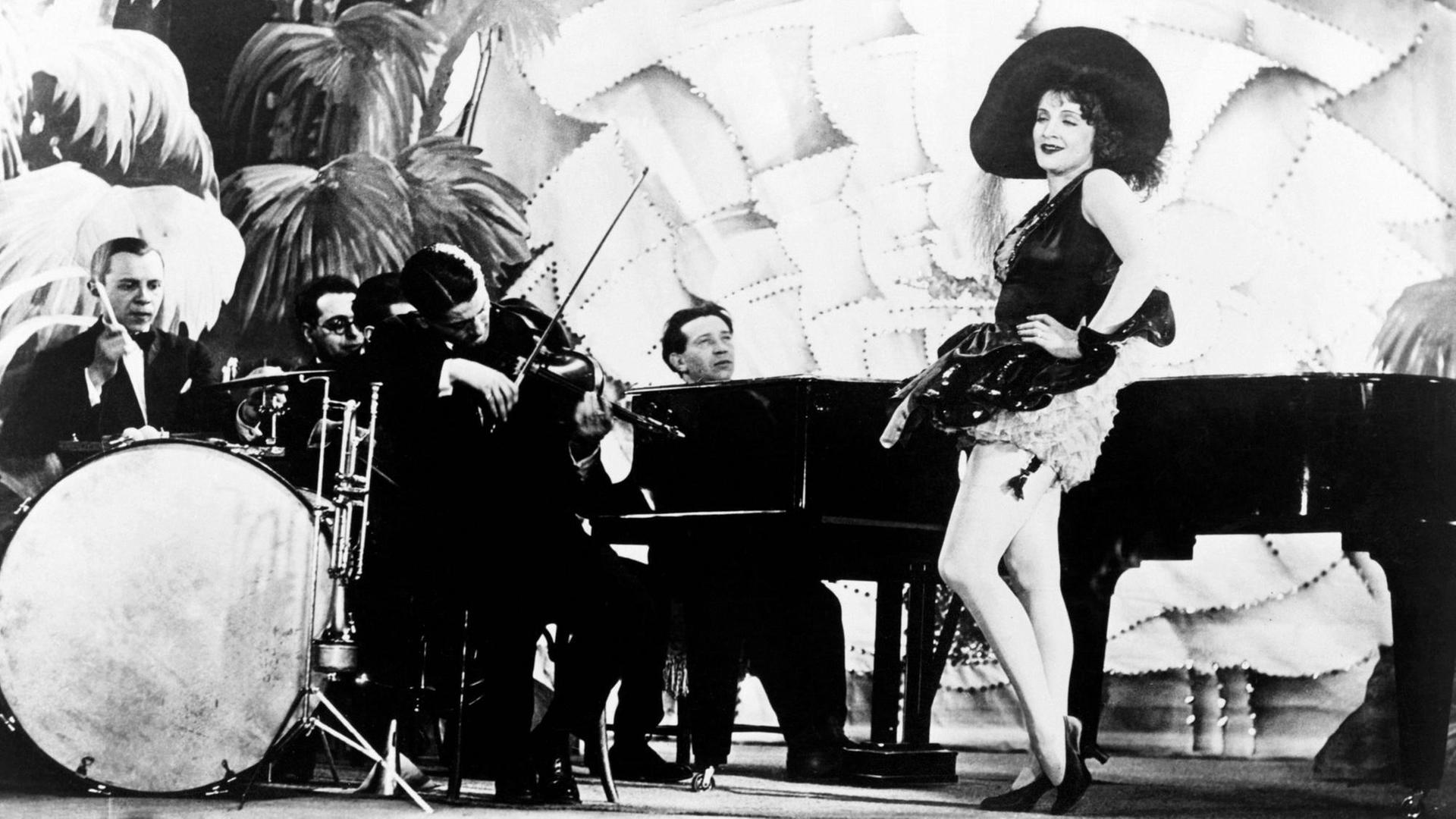 THE BLUE ANGEL, aka DER BLAUE ENGEL, Marlene Dietrich, right, accompanied by Die Weintraub Syncopators, and Friedrich Hollaender, on piano, 1930 Courtesy Everett Collection PUBLICATIONxINxGERxSUIxAUTxONLY Copyright: xCourtesyxEverettxCollectionx MBDBLAN EC111 THE BLUE ANGEL, aka DER BLAUE ENGEL, Marlene Dietrich, right, accompanied by Die Weintraub Syncopators, and Friedrich Hollaender, on piano, 1930 Courtesy Everett Collection PUBLICATIONxINxGERxSUIxAUTxONLY Copyright: xCourtesyxEverettxCollectionx MBDBLAN EC111