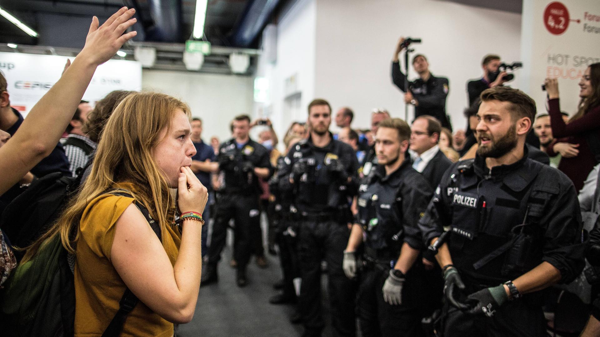 Linke demonstrieren unter Polizeipräsenz gegen ein Podium des rechsgerichteten Antaios Verlags auf der Frankfurter Buchmesse im Jahr 2017. Linke demonstrieren unter Polizeipräsenz gegen ein Podium des rechsgerichteten Antaios Verlags auf der Frankfurter Buchmesse im Jahr 2017.