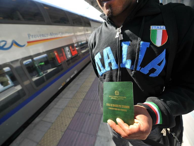 Ein illegaler Flüchtling zeigt am Bahnhof in der italienischen Grenzstadt Ventimiglia seine befristete Aufenthaltserlaubnis.