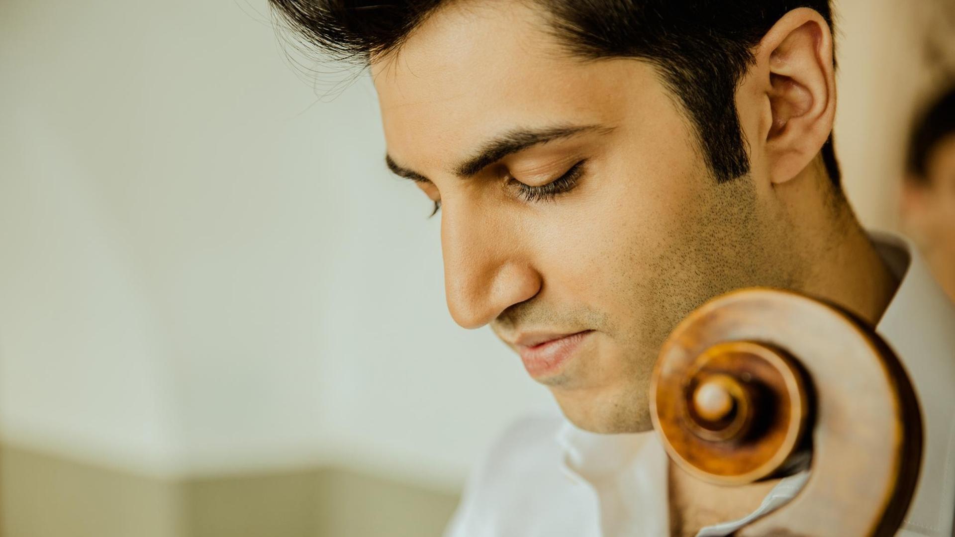 Nahaufnahme des österreichisch-iranische Cellisten Kian Soltani, zu sehen außerdem die Celloschnecke Nahaufnahme des österreichisch-iranische Cellisten Kian Soltani, zu sehen außerdem die Celloschnecke