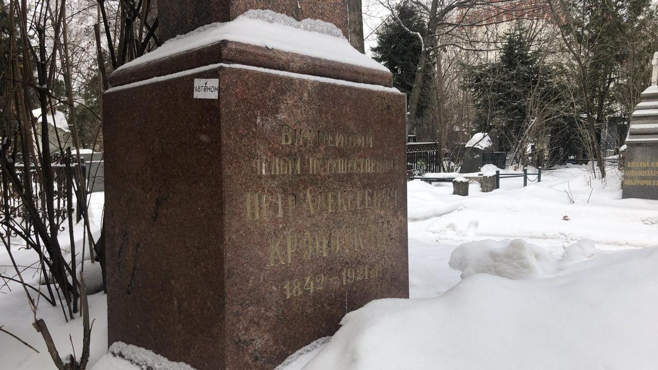 Kropotkins Grabstein auf einem Moskauer Friedhof (brauner Marmor, eingeschneit) - an der Seite ein Aufkleber mit dem russischen Wort für "autonom". Kropotkins Grabstein auf einem Moskauer Friedhof (brauner Marmor, eingeschneit) - an der Seite ein Aufkleber mit dem russischen Wort für "autonom".