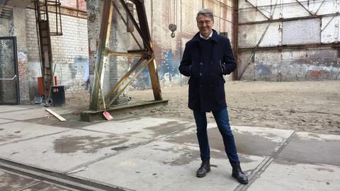 Thilo Gollan steht in einer alten Fabrikhalle auf dem Gelände der Kulturwerft.