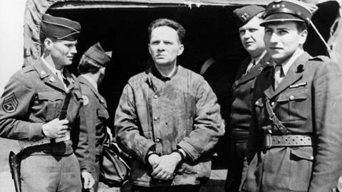 Der Kommandant des Konzentrationslagers Auschwitz, Rudolf Höss (Mitte), steht Mitte der 40er-Jahre auf dem Flugplatz in Nürnberg. Er wird zusammen mit einer Gruppe Offiziere nach Polen ausgeliefert.