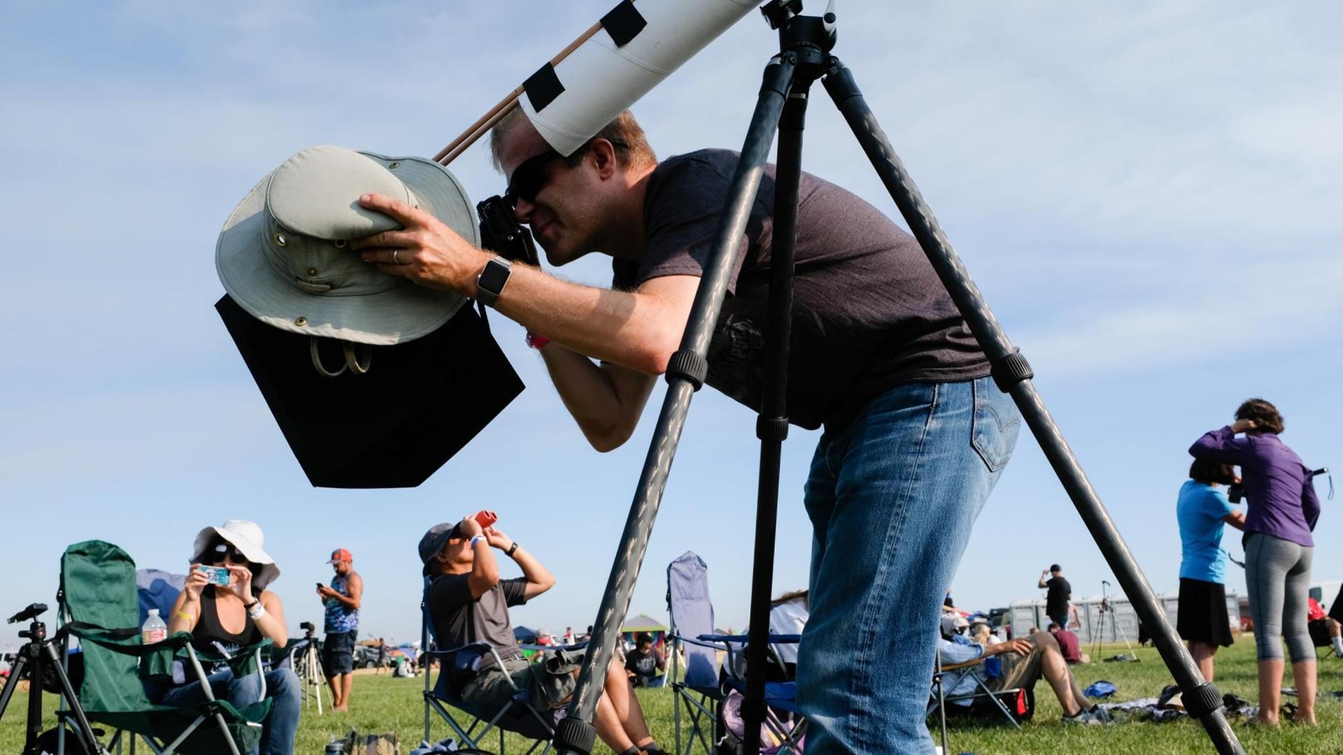 Scott Atwood aus Campbell, Kalifornien, beobachtet den Beginn der Sonnenfinsternis durch eine selbstgebaute Lochkamera am 21. August 2017 in Madras, Oregon. Scott Atwood aus Campbell, Kalifornien, beobachtet den Beginn der Sonnenfinsternis durch eine selbstgebaute Lochkamera am 21. August 2017 in Madras, Oregon.