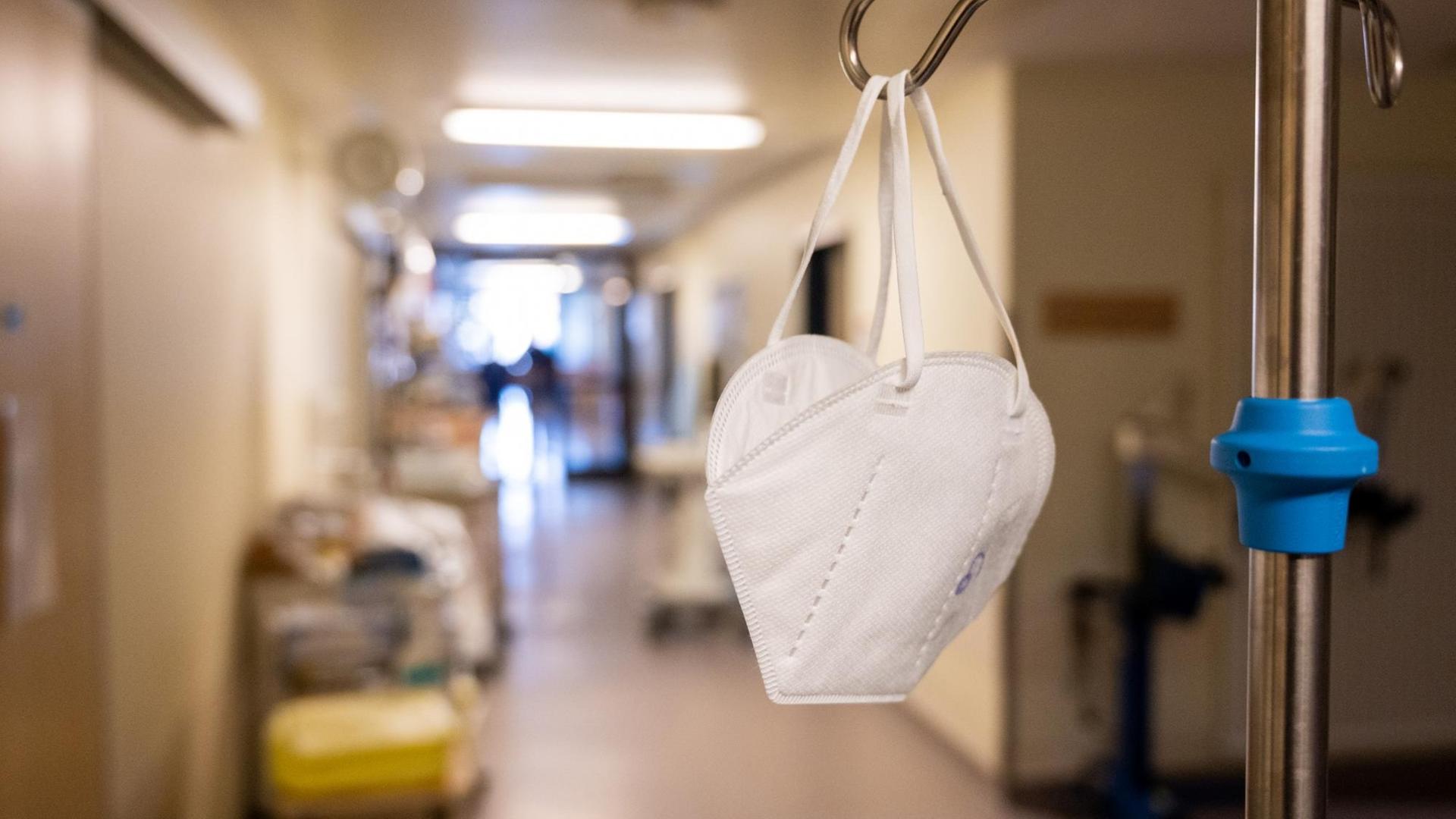 In einem Flur der Intensivstation in der Coronapatienten mit schweren Krankheitsverläufen behandelt werden hängt eine Mund-Nasen-Schutz-Maske. In einem Flur der Intensivstation in der Coronapatienten mit schweren Krankheitsverläufen behandelt werden hängt eine Mund-Nasen-Schutz-Maske.