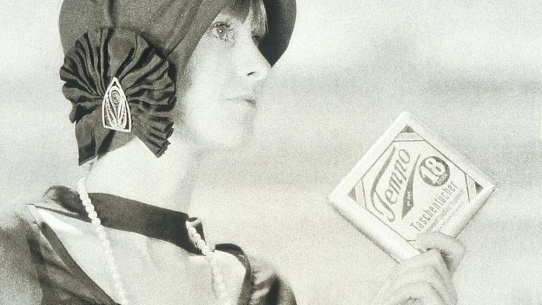 Eine Frau in 1920er-Jahre-Mode mit einem Päckchen Tempotaschentücher. Eine Frau in 1920er-Jahre-Mode mit einem Päckchen Tempotaschentücher.