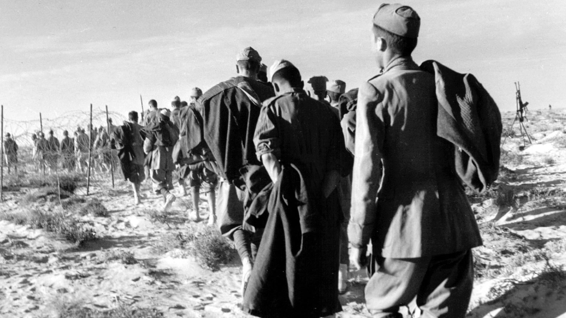 Italienische Kriegsgefangene, die an deutscher Seite kämpften, während der Schlacht von El Alamain. Der Afrikafeldzug unter Generalfeldmarschall Erwin Rommel ("Wüstenfuchs") scheiterte in den von Juni bis November 1942 andauernden Kämpfen bei El Alamain. Trotz des Befehls Adolf Hitlers an Rommel, seinen Truppen "keinen anderen Weg zu zeigen als den zum Siege oder zum Tode" zog sich Rommel angesichts der britischen Übermacht zurück. Im März 1943 kapitulierten die Streitkräfte der Achsenmächte in Afrika. Italienische Kriegsgefangene, die an deutscher Seite kämpften, während der Schlacht von El Alamain. Der Afrikafeldzug unter Generalfeldmarschall Erwin Rommel ("Wüstenfuchs") scheiterte in den von Juni bis November 1942 andauernden Kämpfen bei El Alamain. Trotz des Befehls Adolf Hitlers an Rommel, seinen Truppen "keinen anderen Weg zu zeigen als den zum Siege oder zum Tode" zog sich Rommel angesichts der britischen Übermacht zurück. Im März 1943 kapitulierten die Streitkräfte der Achsenmächte in Afrika.