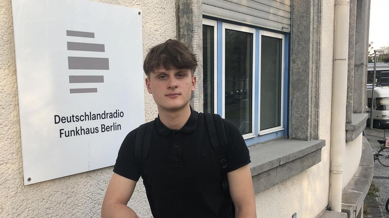 Ein dunkelhaariger Junge mit dunklem T-Shirt und Jeans auf der Treppe des Funkhauses von Deutschlandfunk Kultur. Ein dunkelhaariger Junge mit dunklem T-Shirt und Jeans auf der Treppe des Funkhauses von Deutschlandfunk Kultur.