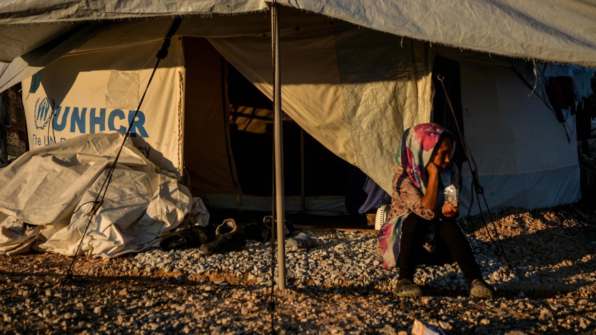 Eine Frau sitzt vor dem geöffneten Eingang eines UNHCR-Hilfszeltes im Flüchtlingscamp Kara Tepe Eine Frau sitzt vor dem geöffneten Eingang eines UNHCR-Hilfszeltes im Flüchtlingscamp Kara Tepe