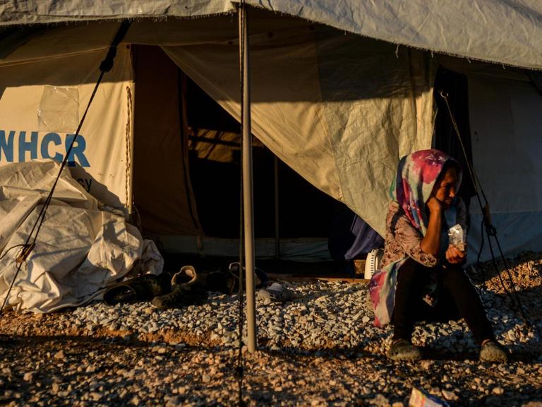 Eine Frau sitzt vor dem geöffneten Eingang eines UNHCR-Hilfszeltes im Flüchtlingscamp Kara Tepe
