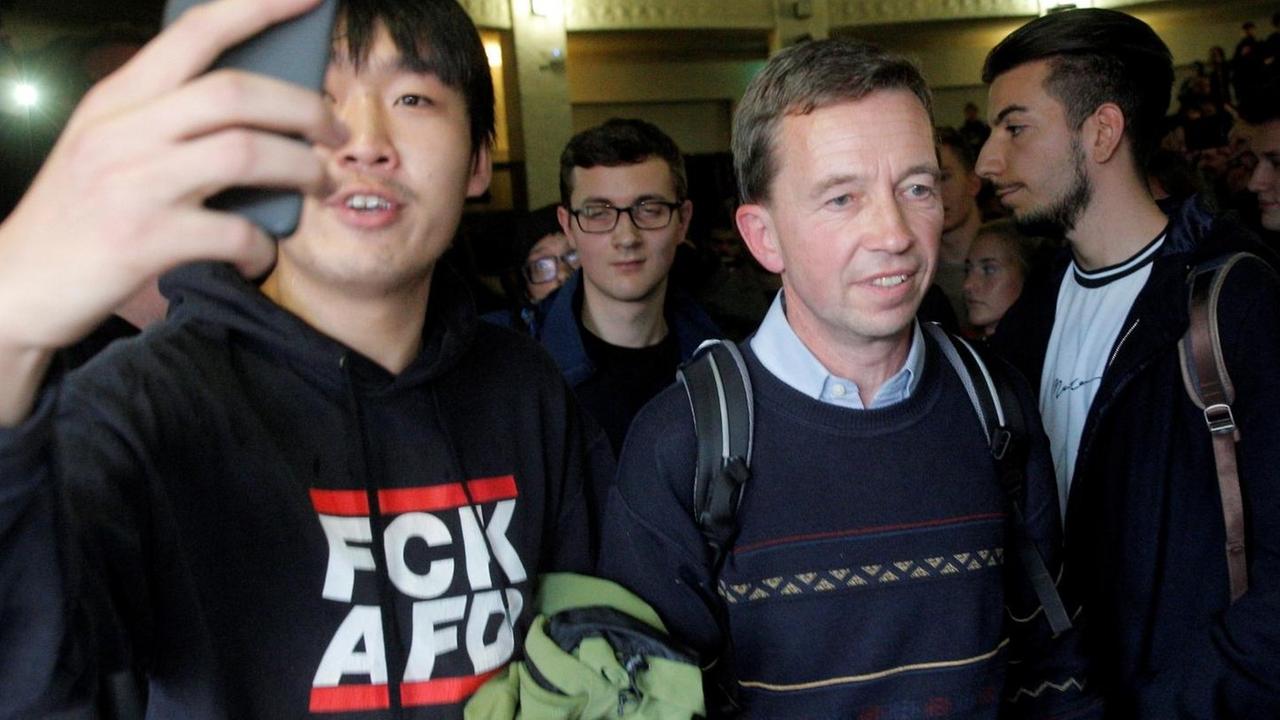 Bernd Lucke drängt sich nach seiner verhinderten Vorlesung aus dem Saal. Neben ihm ein Demonstrant in einem Pullover mit der Aufschrift "FCK AFD". Bernd Lucke drängt sich nach seiner verhinderten Vorlesung aus dem Saal. Neben ihm ein Demonstrant in einem Pullover mit der Aufschrift "FCK AFD".