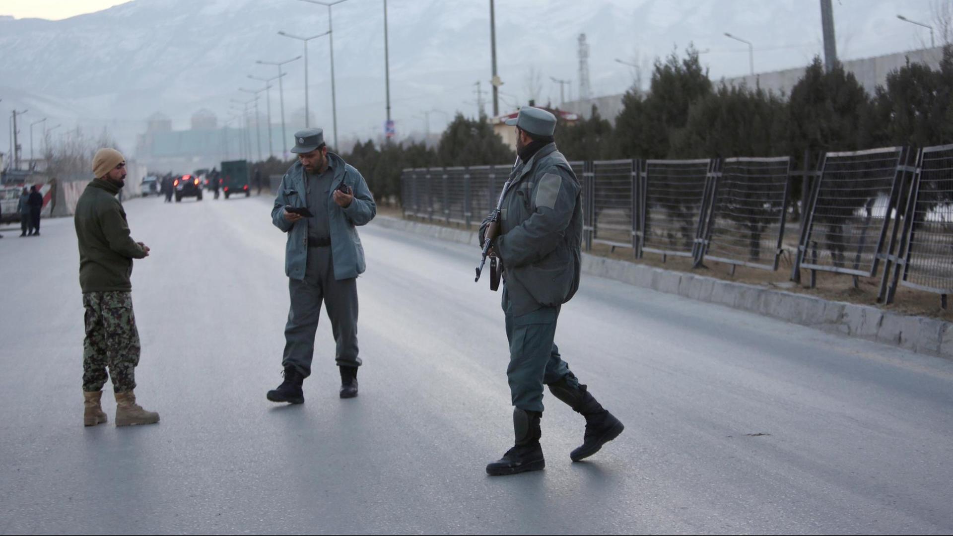 Mitglieder der afghanischen Sicherheitskräfte stehen am 10.01.2017 nahe des Ortes zweier Explosionen in Kabul (Afghanistan). Bei einem doppelten Autobombenanschlag könnten im Zentrum der afghanischen Hauptstadt Kabul nach Medienberichten bis zu 50 Menschen getötet worden sein.