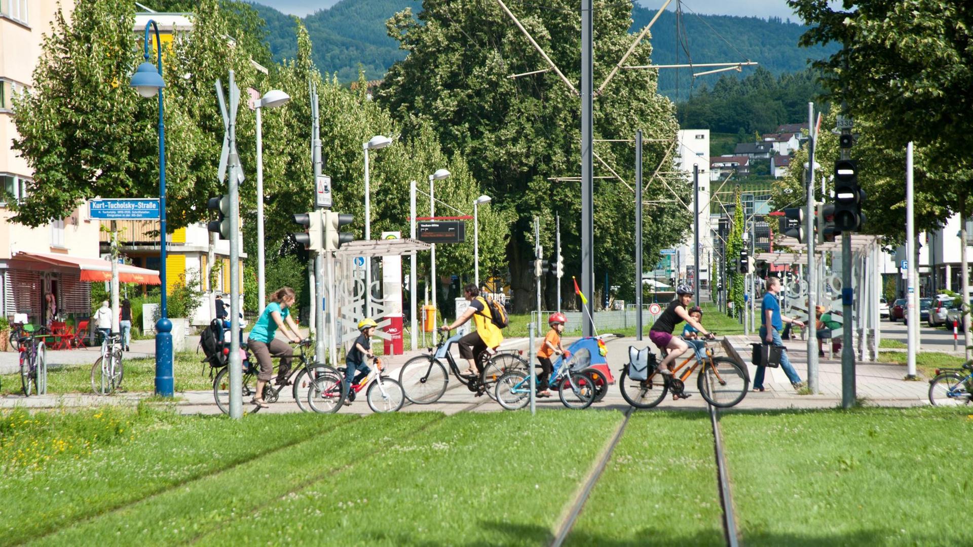 In der autofreien Siedlung Vauban queren Fahrradfahrer eine Straßenbahnlinie. In der autofreien Siedlung Vauban queren Fahrradfahrer eine Straßenbahnlinie.