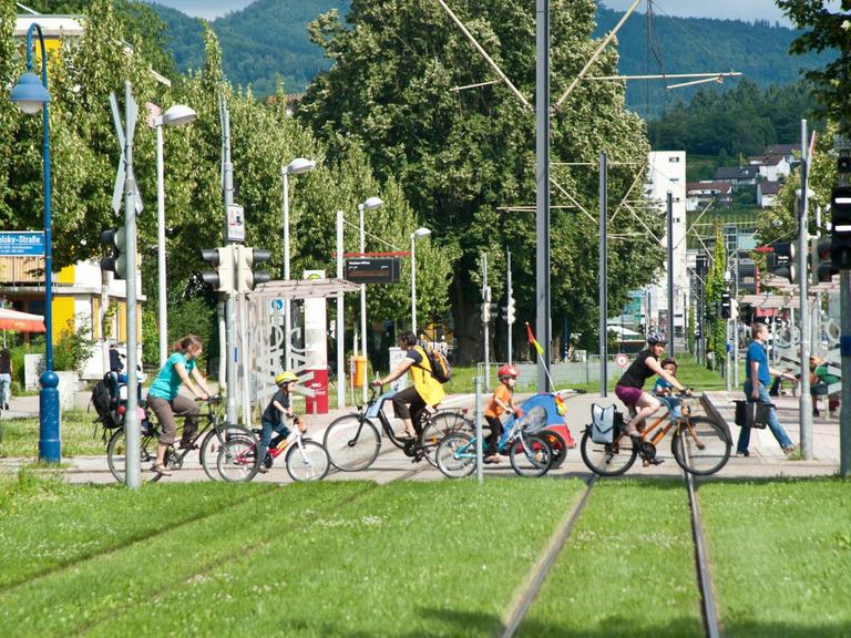 In der autofreien Siedlung Vauban queren Fahrradfahrer eine Straßenbahnlinie.