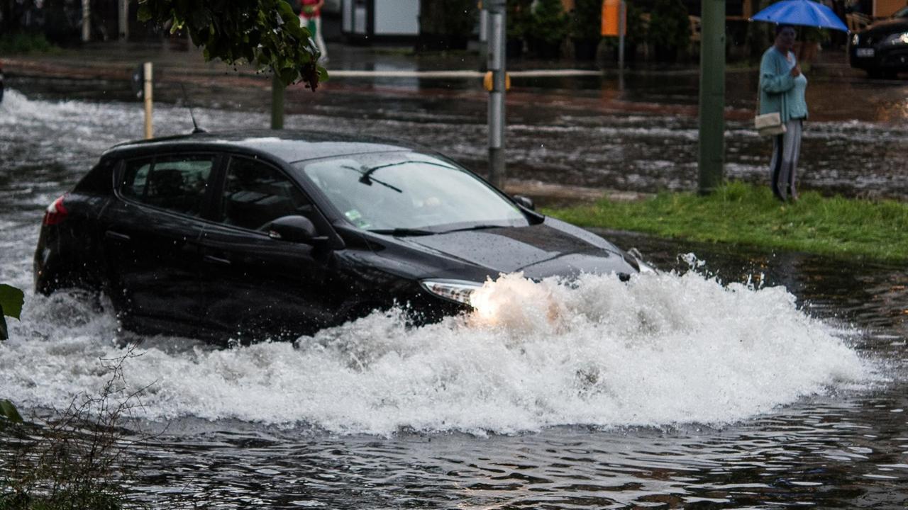 Ein Pkw fährt in Berlin nach einem Gewitter und starken Regenfällen durch die Wassermassen in der Breiten Straße. Ein Pkw fährt in Berlin nach einem Gewitter und starken Regenfällen durch die Wassermassen in der Breiten Straße.