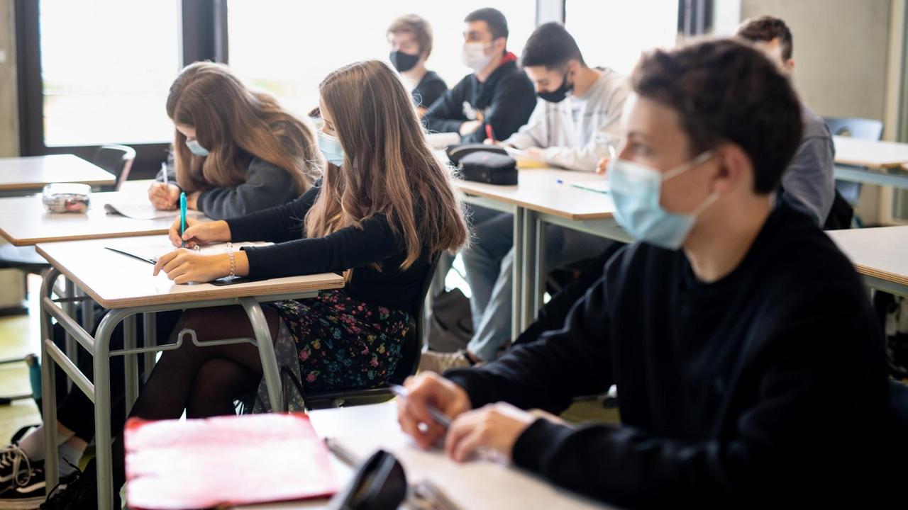 Schülerinnen und Schüler nehmen mit Mund- und Nasenschutz am Unterricht in einem Geographie-Seminar in der Jahrgangsstufe elf am staatlichen Gymnasium Trudering teil.