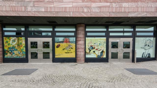 Der Schauraum"Comic + Cartoon" von außen mit großflächigen Plakaten von Comicfiguren wie Popeye oder Donald Duck.