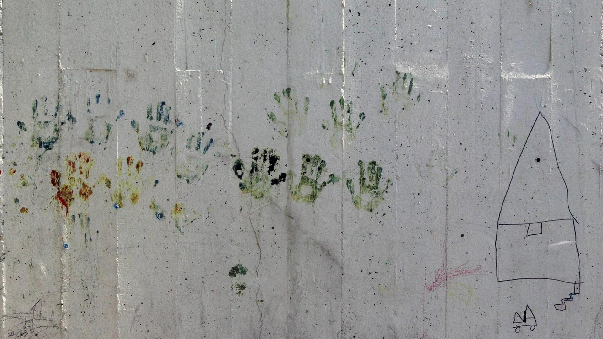 Flüchtlinge haben an einer Mauer im Hafen Piräus ihre Handabdrücke hinterlassen. Flüchtlinge haben an einer Mauer im Hafen Piräus ihre Handabdrücke hinterlassen.