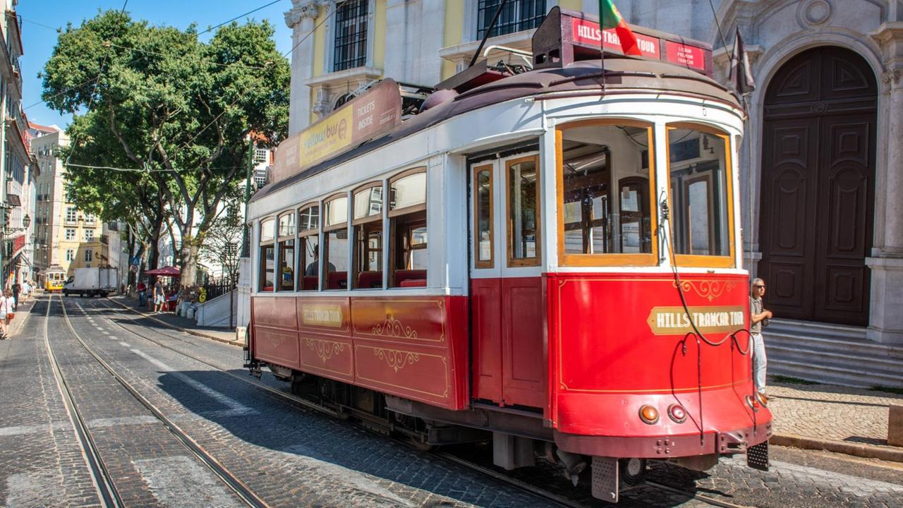 Eine alte Straßenbahn fährt durch Lissabons Altstadt. Eine alte Straßenbahn fährt durch Lissabons Altstadt.