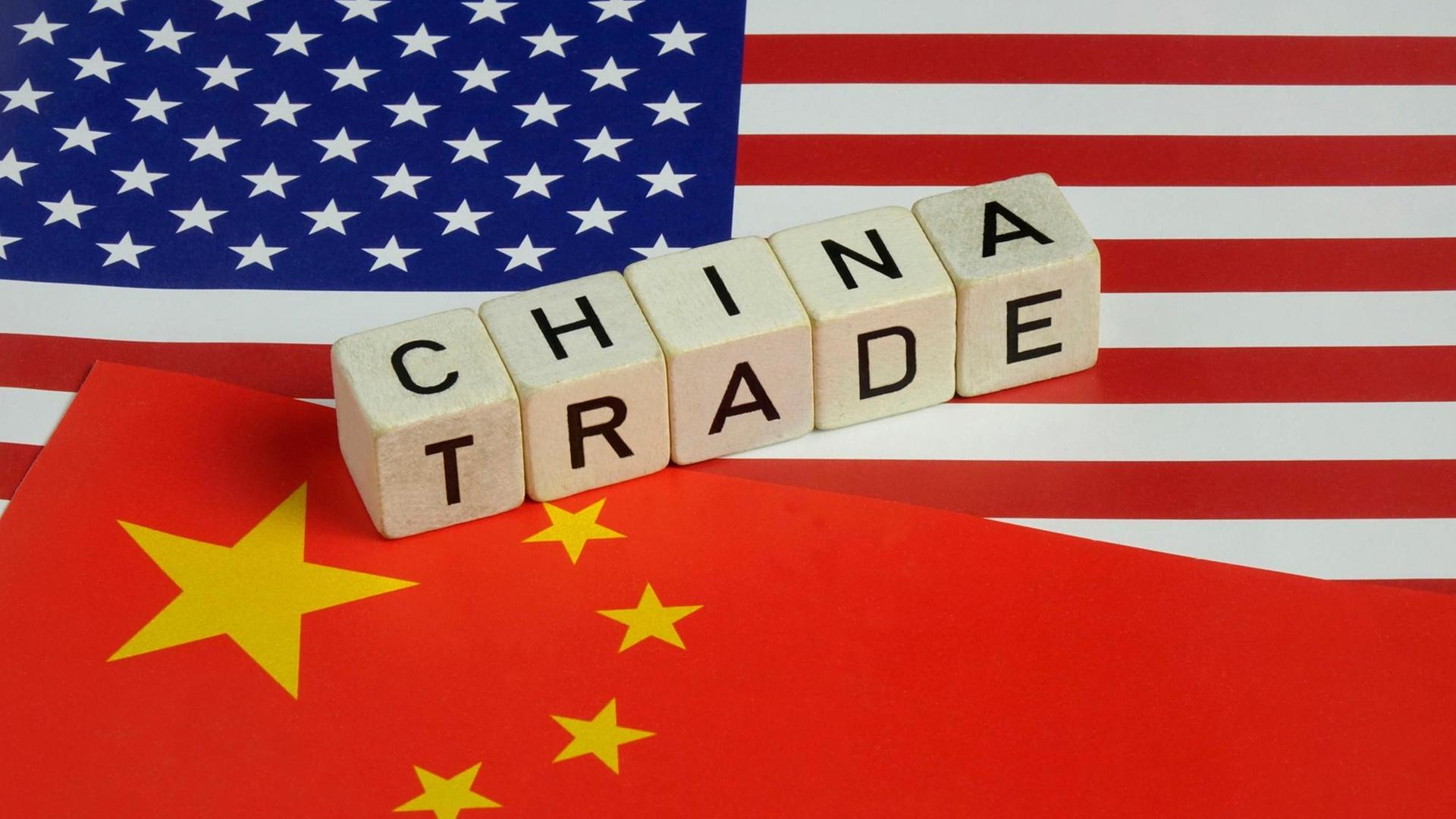 Auf einer chinesischen und amerikanischen Flagge liegen die Worte China Trade. Auf einer chinesischen und amerikanischen Flagge liegen die Worte China Trade.