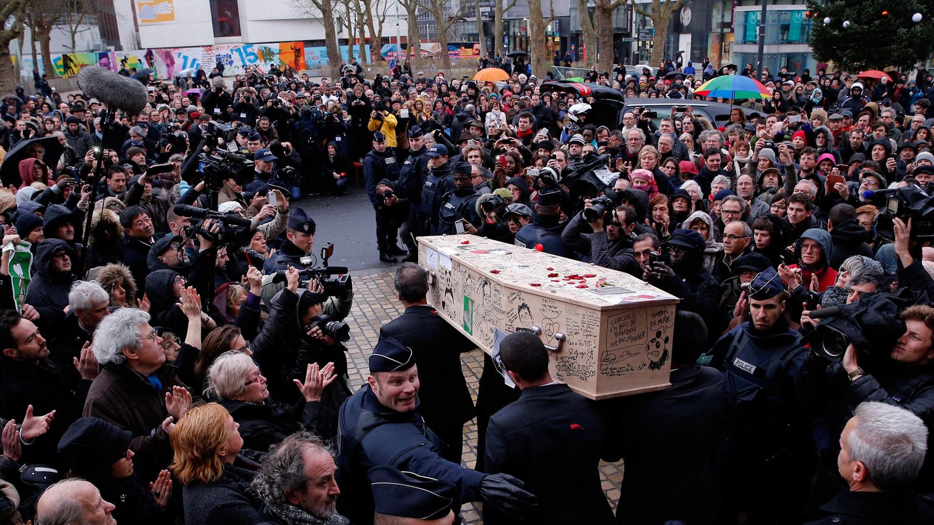 Der Sarg des "Charlie Hebdo"-Zeichners Tignous wird aus dem Rathaus von Montreuil getragen. Der Sarg des "Charlie Hebdo"-Zeichners Tignous wird aus dem Rathaus von Montreuil getragen.