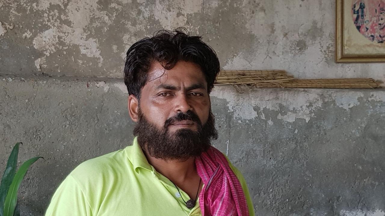 Gauri Shankar Sharma, der Priester des Yamuna-Tempels in Delhi, trägt Vollbart, ein gelbes Poloshirt und ein rotes Tuch über der linken Schulter. Gauri Shankar Sharma, der Priester des Yamuna-Tempels in Delhi, trägt Vollbart, ein gelbes Poloshirt und ein rotes Tuch über der linken Schulter.