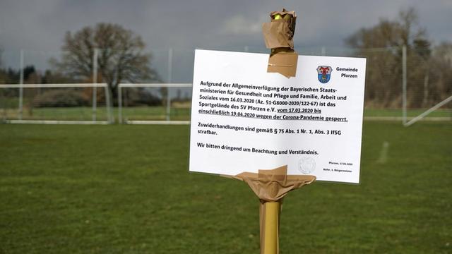 Wegen der Coronakrise ist Sport in den Vereinen in Deutschland derzeit verboten. Ein Schild mitten auf dem Fussballplatz warnt die Bürger in Pforzen im Allgäuf vor der Benutzung des Platzes.