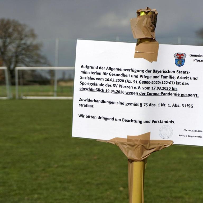 Wegen der Coronakrise ist Sport in den Vereinen in Deutschland derzeit verboten. Ein Schild mitten auf dem Fussballplatz warnt die Bürger in Pforzen im Allgäuf vor der Benutzung des Platzes.