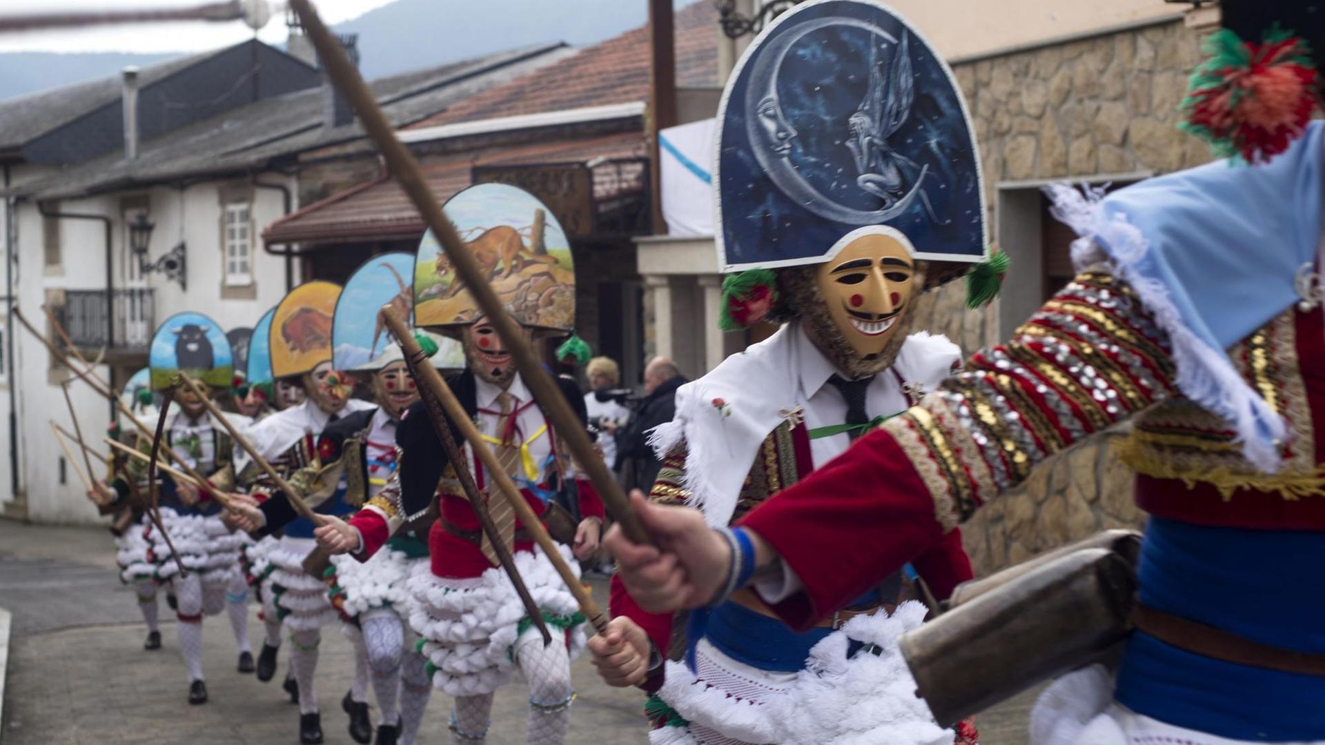 Dorfbewohner rennen maskiert durch die Straßen von Laza in Spanien während des galicischen Karnevals (Entroido de Laza) Dorfbewohner rennen maskiert durch die Straßen von Laza in Spanien während des galicischen Karnevals (Entroido de Laza)