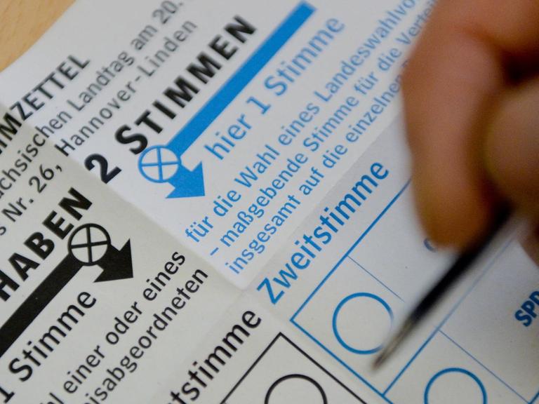 Ein Wähler macht in Hannover auf seinem Stimmzettel die Kreuze.