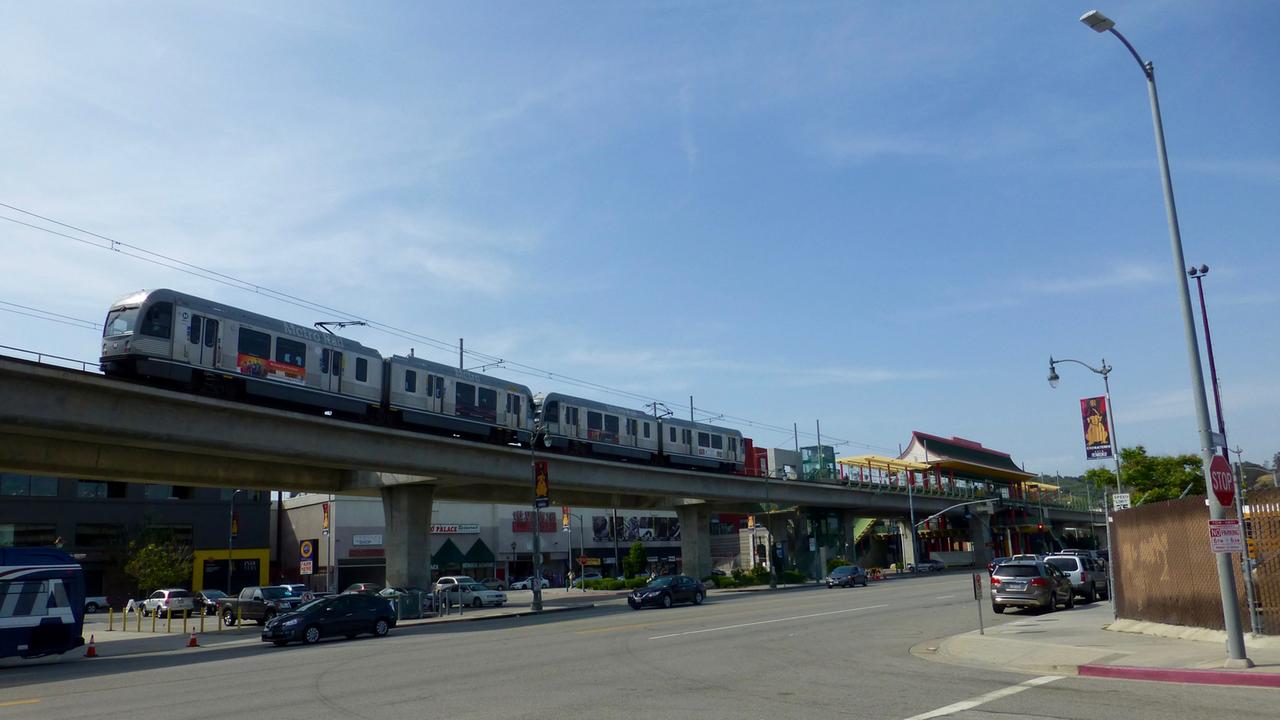 Die Stadtbahn "Gold Line" fährt auf der Hochbahntrasse über eine Straßenkreuzung. Die Stadtbahn "Gold Line" fährt auf der Hochbahntrasse über eine Straßenkreuzung.
