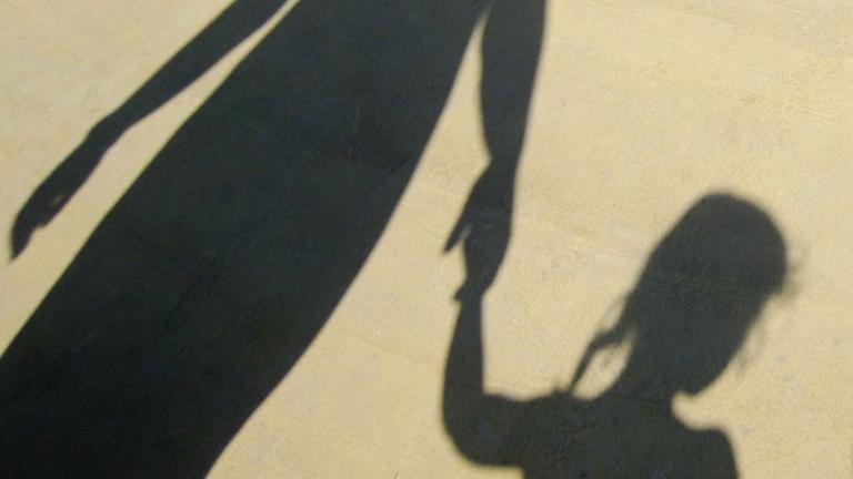 Der Schatten einer Familie, die sich an der Hand hält. Der Schatten einer Familie, die sich an der Hand hält.