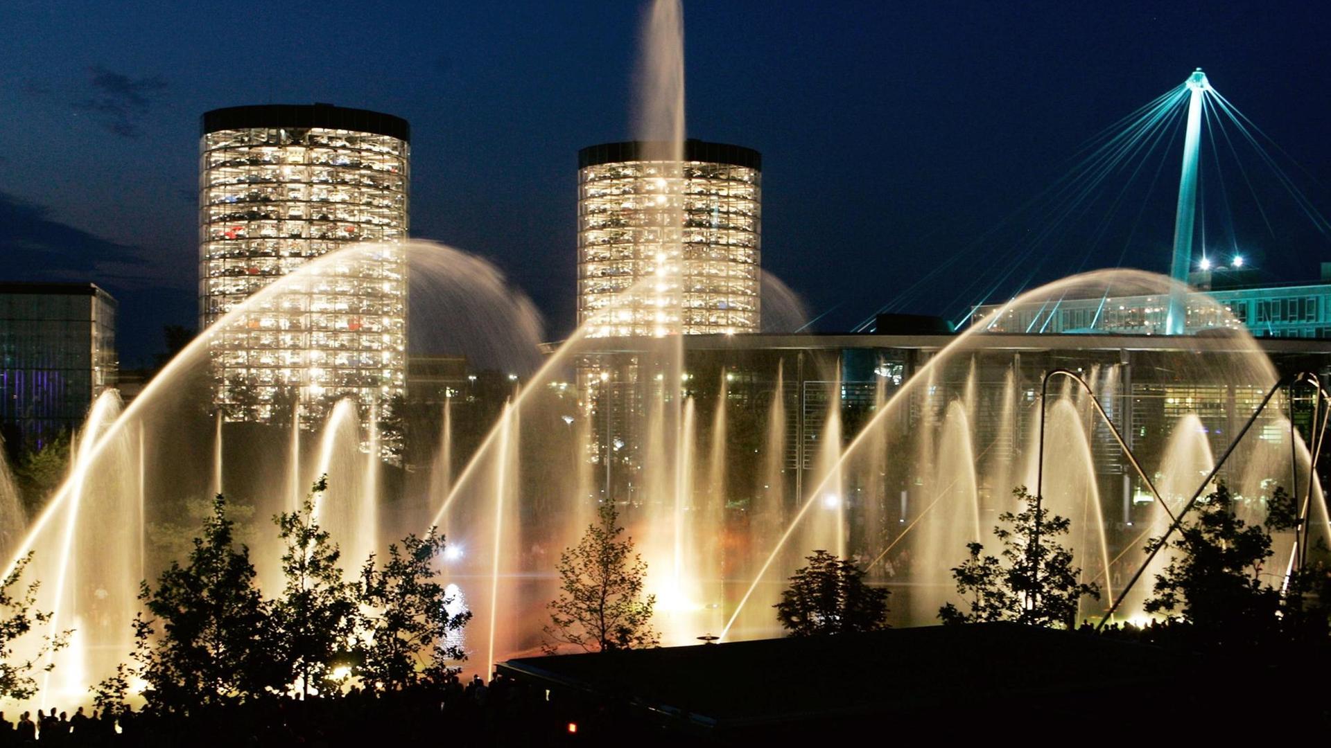 Licht- und Wasserspiele vor dunkelblauem Nachthimmel und zwei beleuchteten Hochhäusern in der Autostadt Wolfsburg Licht- und Wasserspiele vor dunkelblauem Nachthimmel und zwei beleuchteten Hochhäusern in der Autostadt Wolfsburg