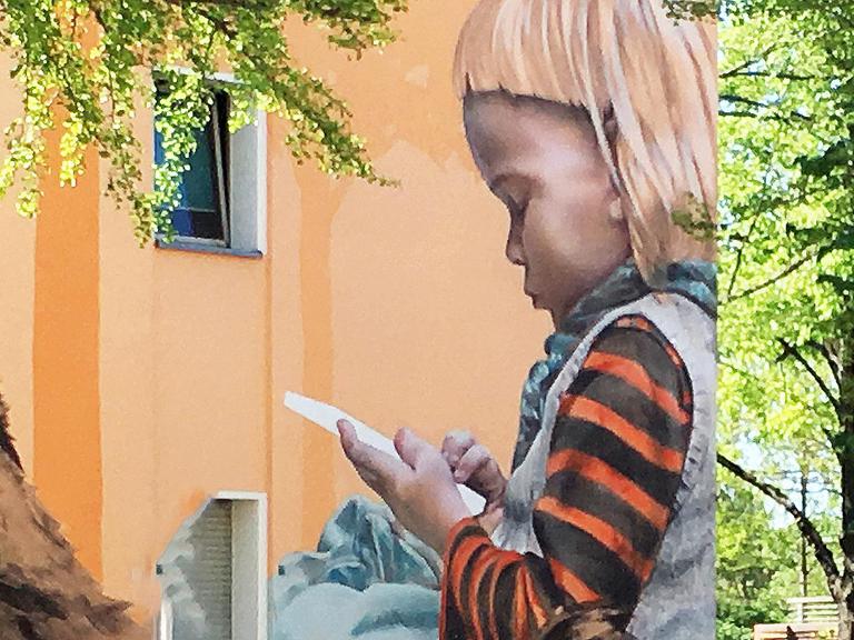 Wandbild von einem Kind mit Smartphone