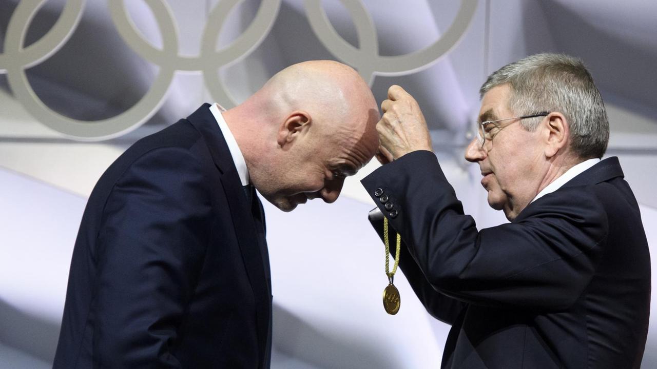 FIFA-Präsident Infantino erhält von IOC-Boss Bach eine Medaille. FIFA-Präsident Infantino erhält von IOC-Boss Bach eine Medaille.
