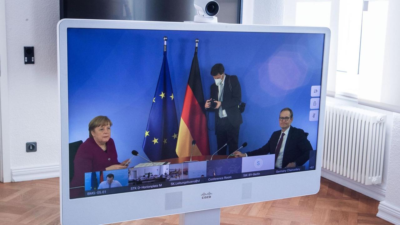Mecklenburg-Vorpommern, Schwerin: Auf einem Monitor in der Staatskanzlei sind bei der Video-Schaltkonferenz zur Entwicklung der Corona-Pandemie Bundeskanzlerin Angela Merkel (CDU) und Michael Müller (SPD), der Regierende Bürgermeister von Berlin zu sehen. Mecklenburg-Vorpommern, Schwerin: Auf einem Monitor in der Staatskanzlei sind bei der Video-Schaltkonferenz zur Entwicklung der Corona-Pandemie Bundeskanzlerin Angela Merkel (CDU) und Michael Müller (SPD), der Regierende Bürgermeister von Berlin zu sehen.