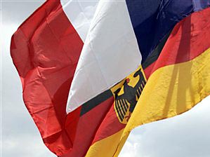 Eine deutsche und eine französische Flagge wehen im Wind.