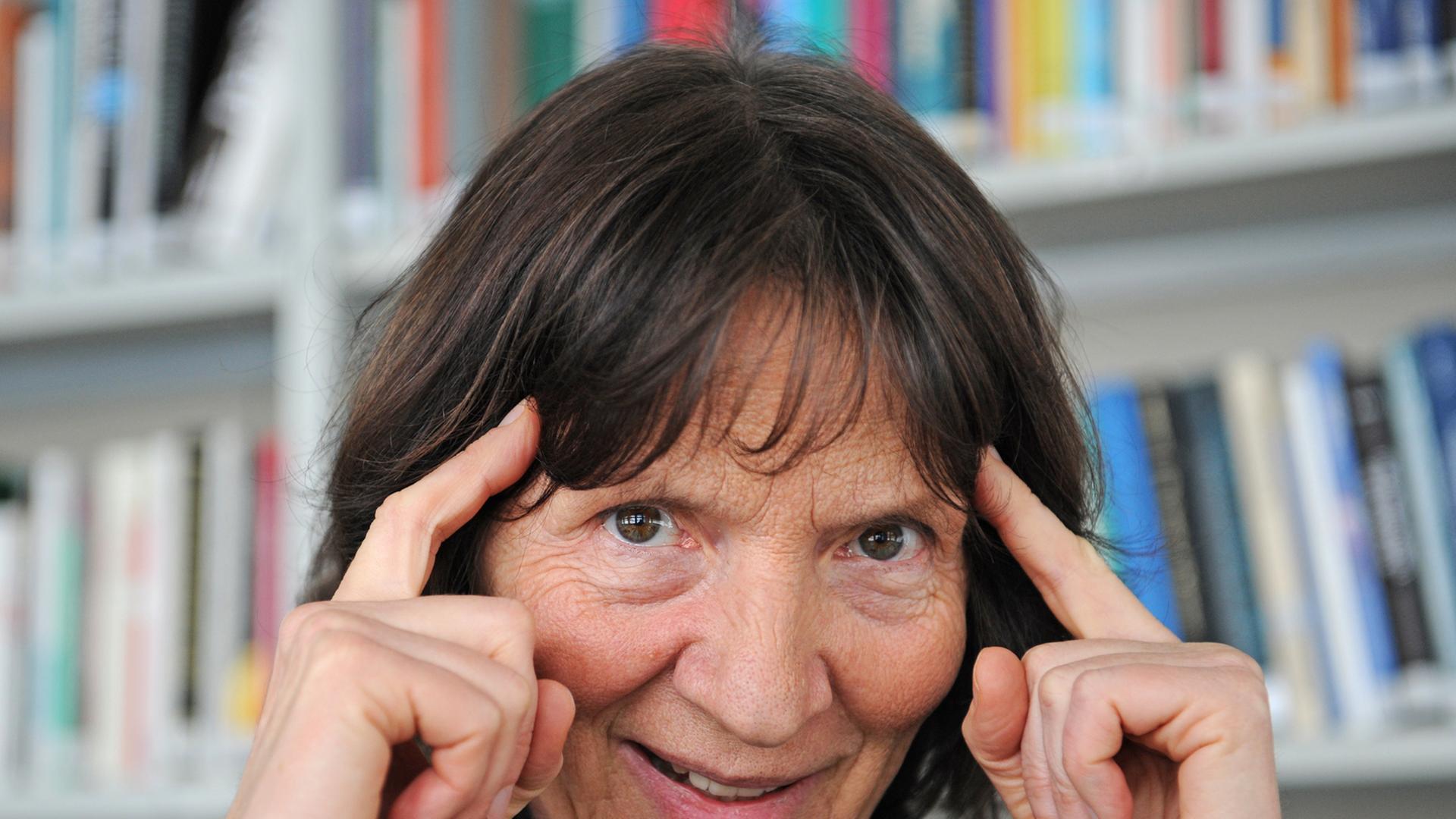 Die Kulturwissenschaftlerin Aleida Assmann, vor einem Bücherregal, hält sich ihre Zeigefingern an die Schläfe. Die Kulturwissenschaftlerin Aleida Assmann, vor einem Bücherregal, hält sich ihre Zeigefingern an die Schläfe.